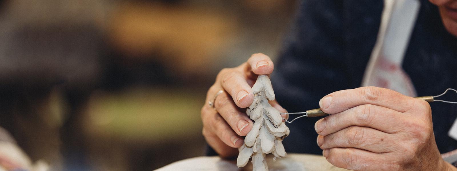 Adult education student carving ceramic tree